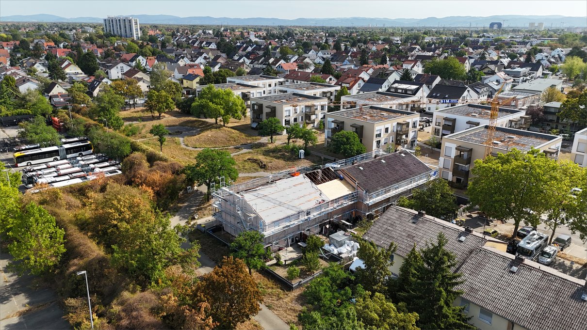 Blick über das Quartier auf die eingerüstete Zeile mit neu verlegter Dachunterspannung